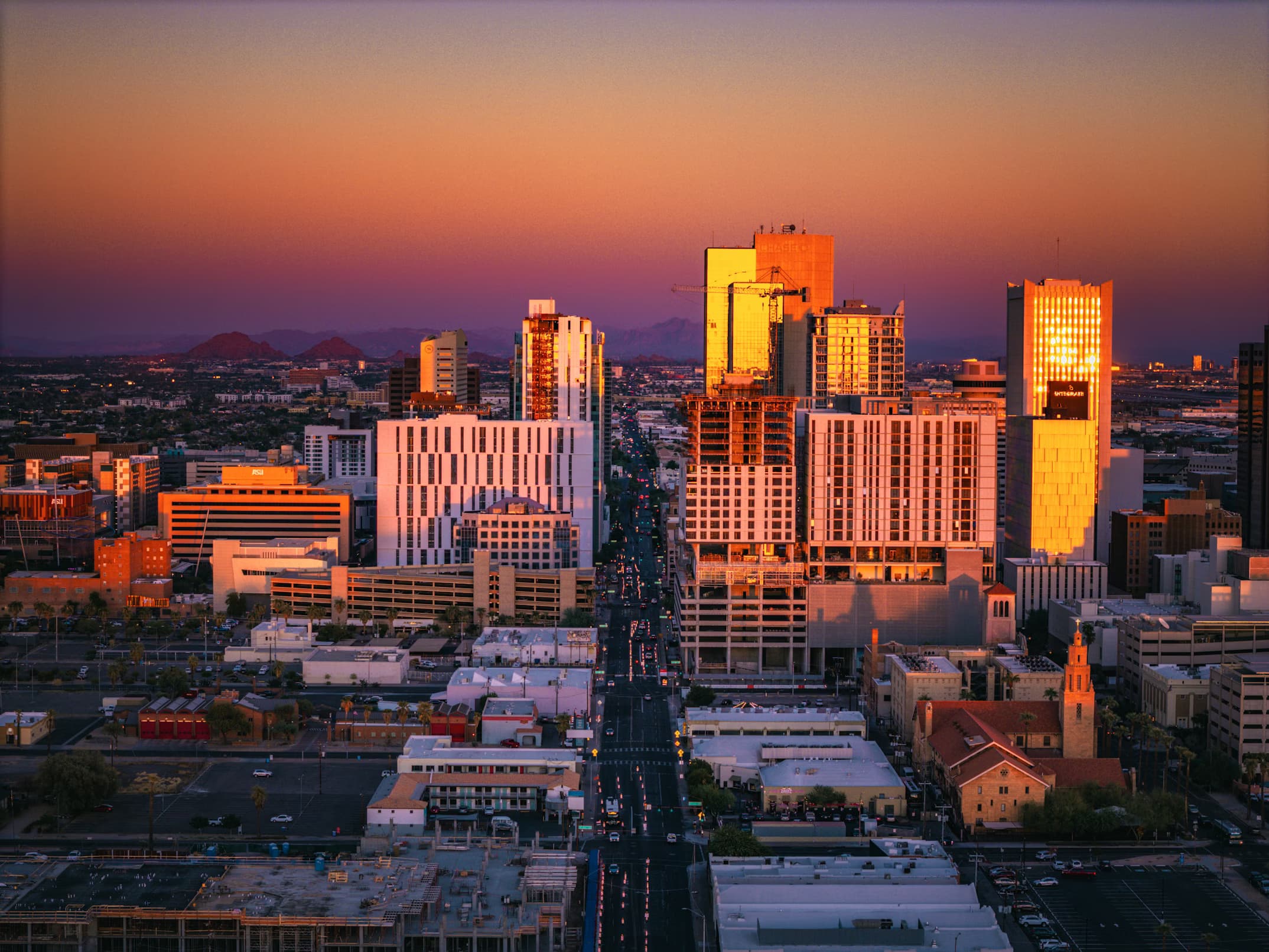 Downtown Phoenix skyline at sunset with mountains in the background