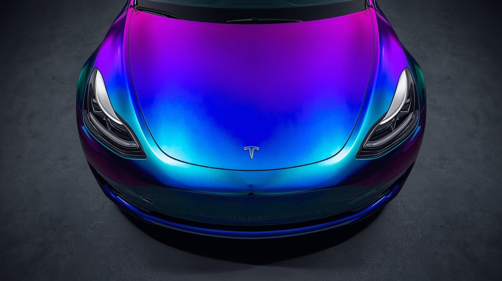 Tesla Model 3 with color-shift purple blue teal vinyl wrap showing futuristic finish