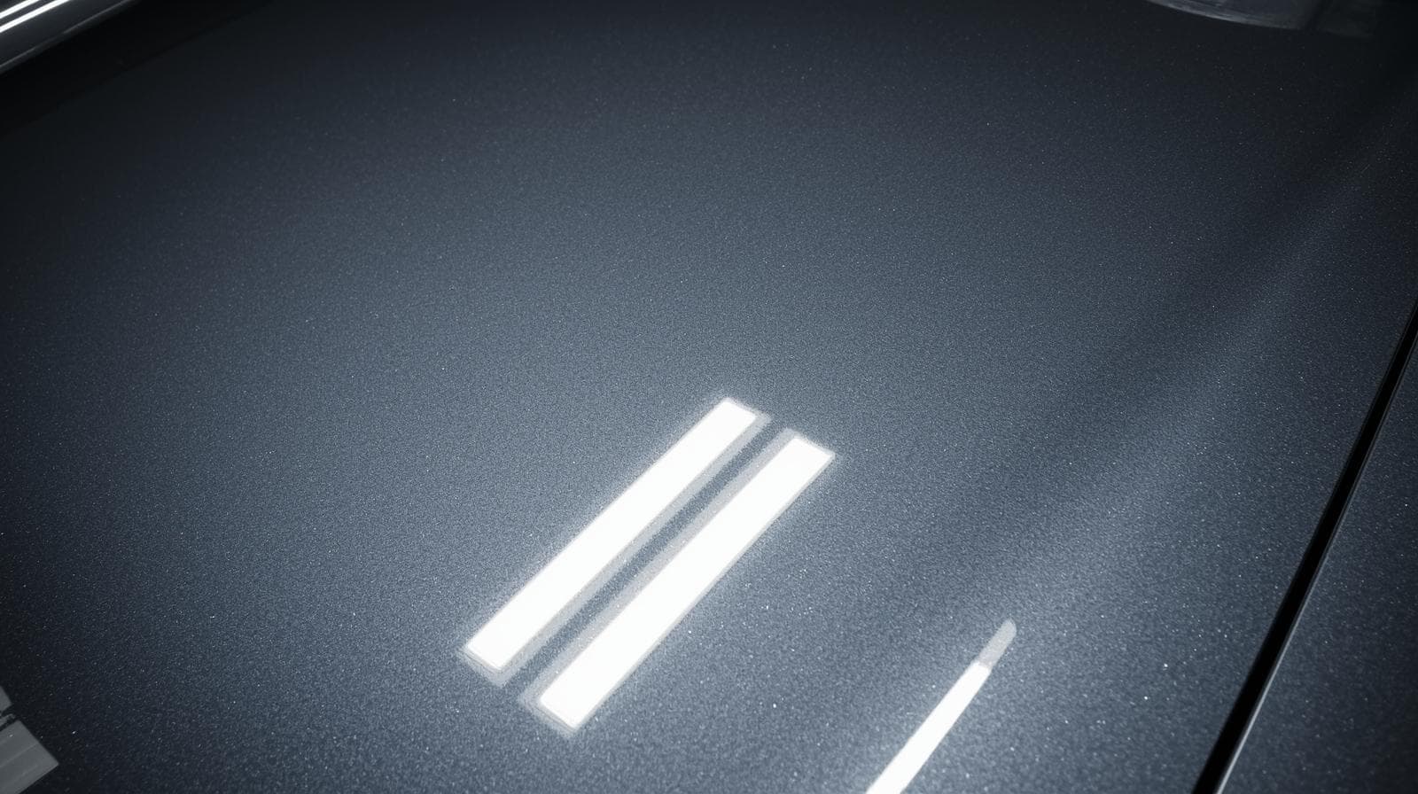 Close-up of glossy vinyl wrap showing mirror-like reflective finish and light refraction