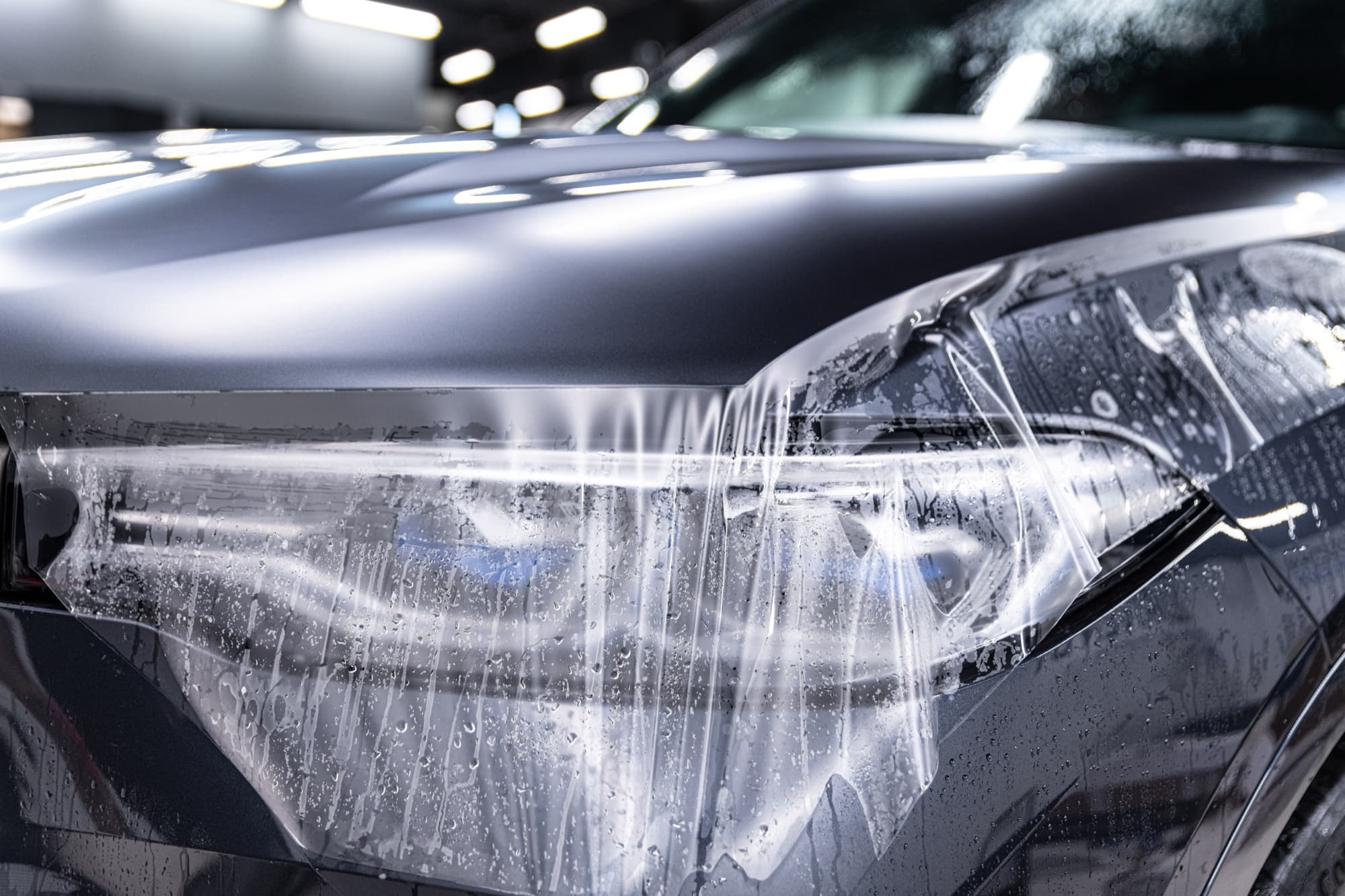 Paint protection film being applied to a car headlight
